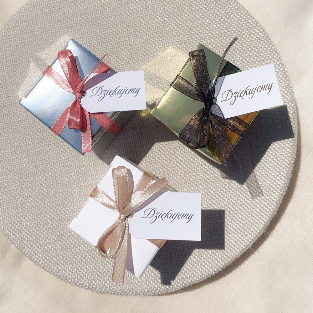 Upominek dla gości, drobny prezent w pudełku z kokardką. Do wyboru pudełko białe, srebrne albo złote. Wypełnienie, do wyboru: herbata sypana, herbata rozkwitająca, słodycze.