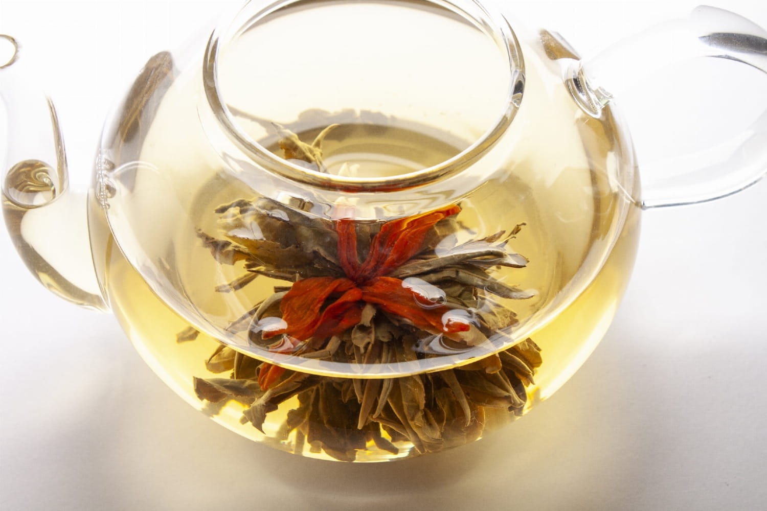 Herbata rozkwitająca Century Love z pomarańczową lilią, po rozkwitnięciu w ciepłej wodzie.