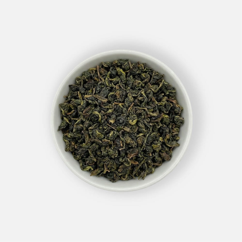 Herbata liściasta Classic Oolong o półfermentowanych liściach, podana w białej miseczce, ujęcie z góry.