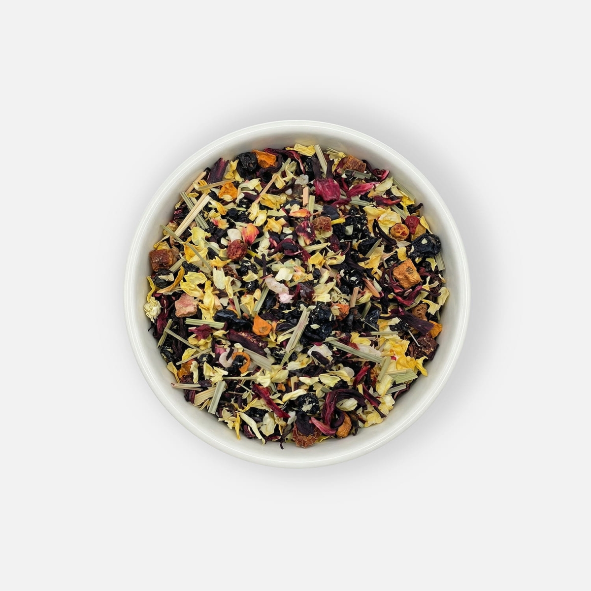 Herbata Twilight Veil z suszonymi owocami, hibiskusem, jaśminem i trawą cytrynową, podana w białej miseczce, ujęcie z góry.