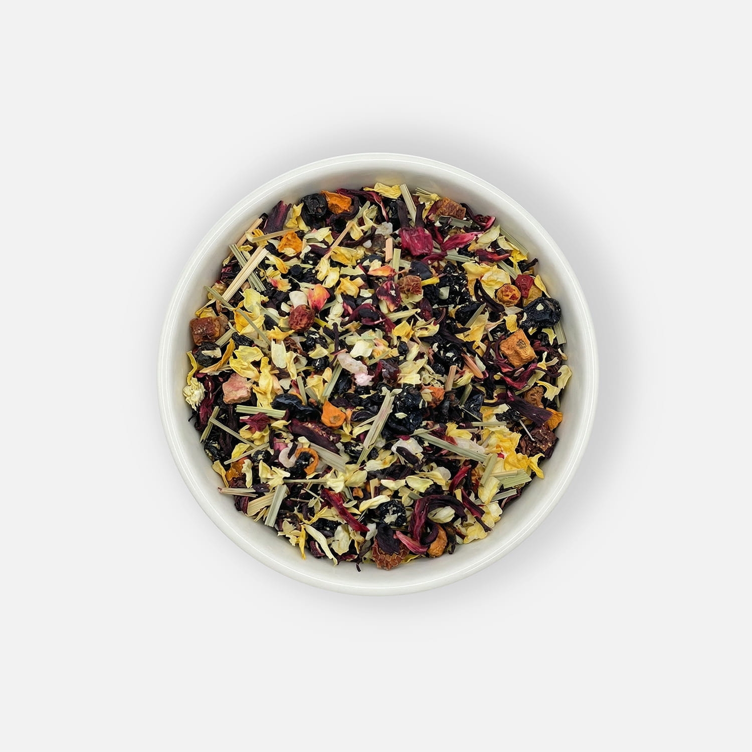 Herbata Twilight Veil z suszonymi owocami, hibiskusem, jaśminem i trawą cytrynową, podana w białej miseczce, ujęcie z góry.