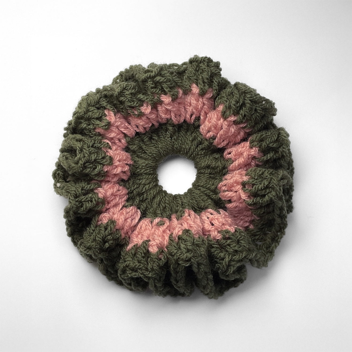 Ręcznie robiona gumka do włosów na szydełku wykonana z materiałów z upcyklingu, widok z góry na białym tle.