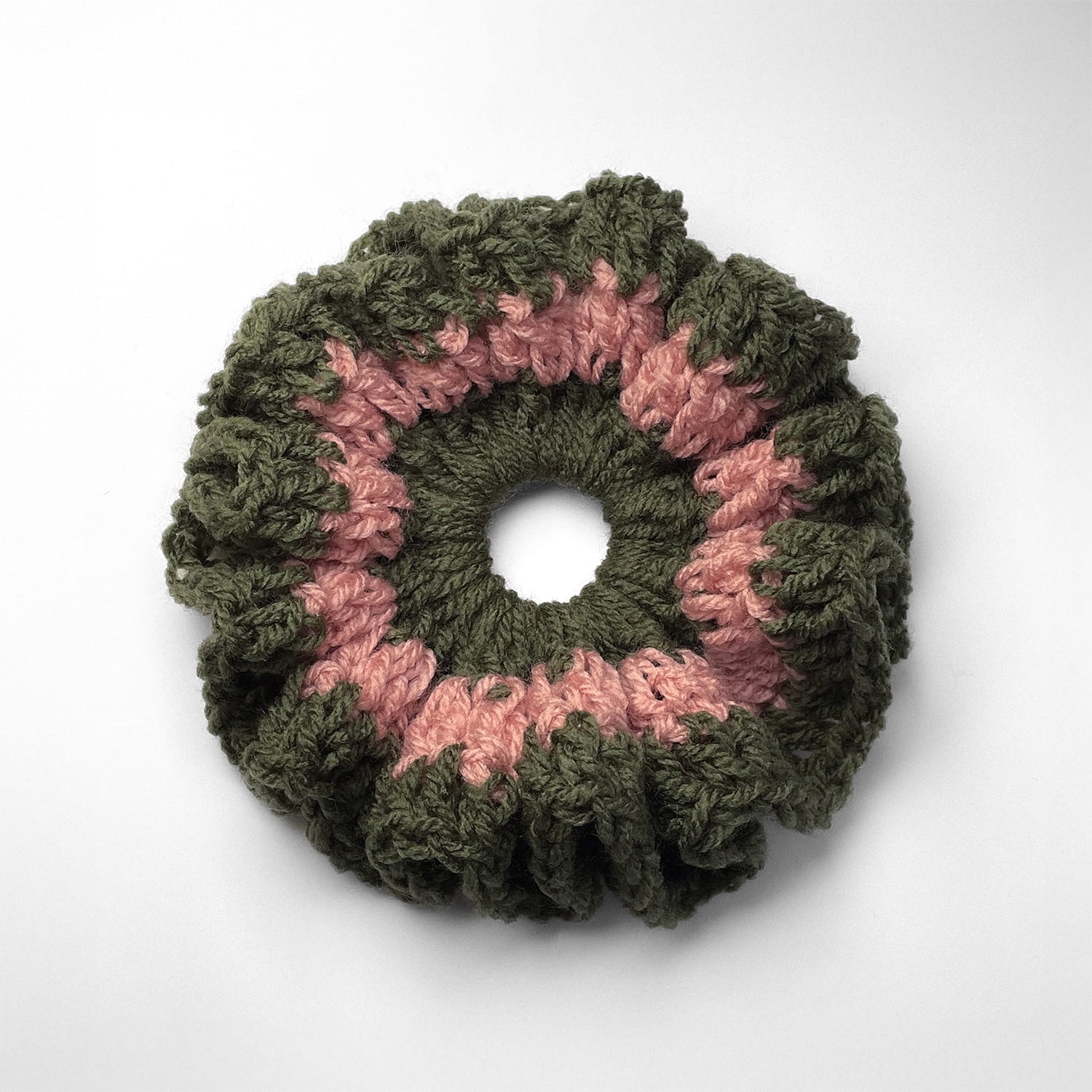 Ręcznie robiona gumka do włosów na szydełku wykonana z materiałów z upcyklingu, widok z góry na białym tle.