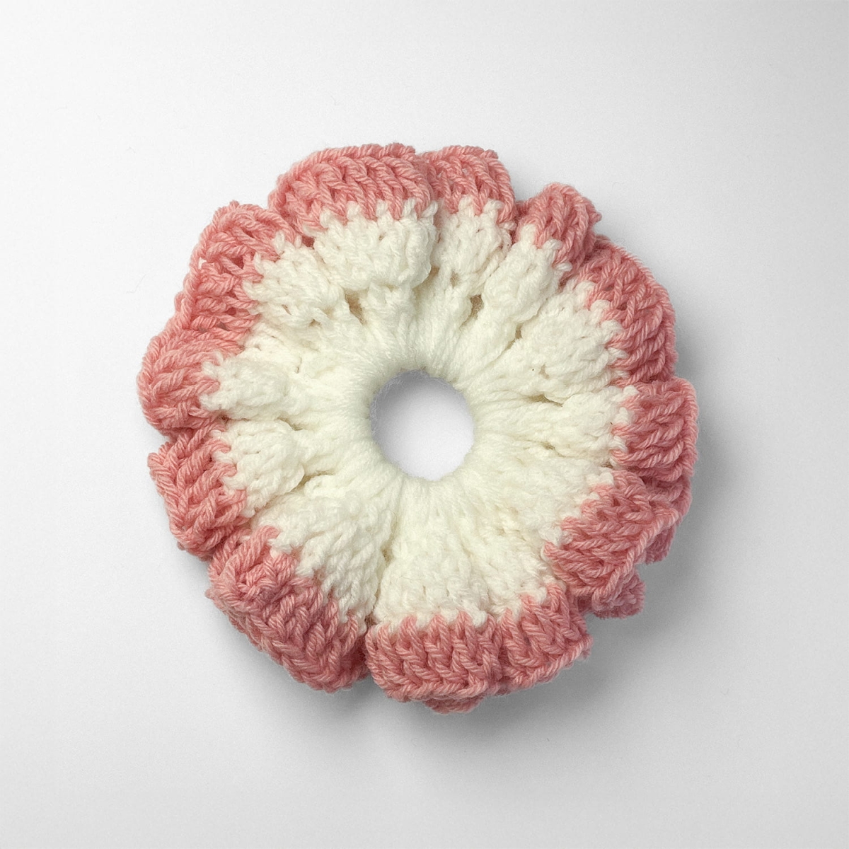 Ręcznie robiona gumka do włosów na szydełku wykonana z materiałów z upcyklingu, widok z góry na białym tle.