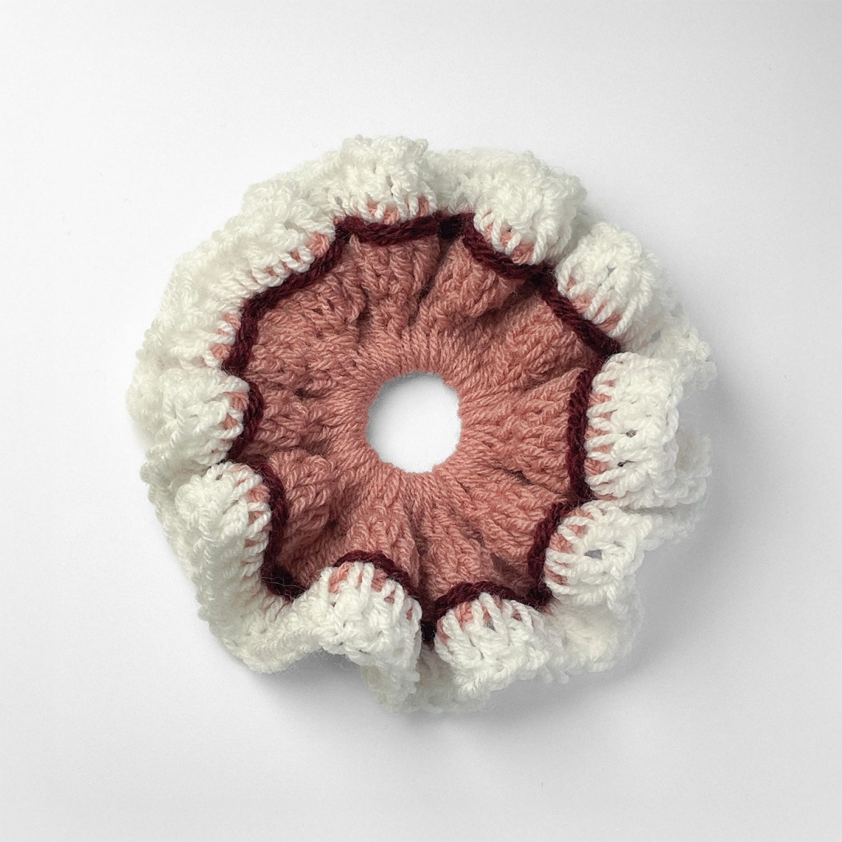 Ręcznie robiona gumka do włosów na szydełku wykonana z materiałów z upcyklingu, widok z góry na białym tle.