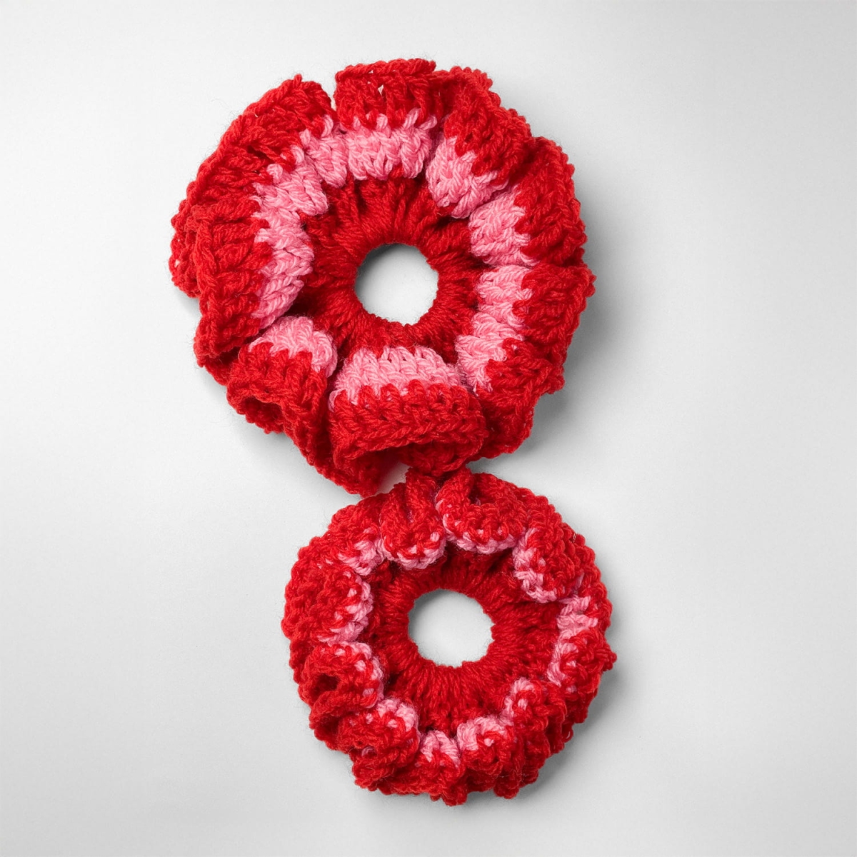 Ręcznie robiona gumka do włosów na szydełku wykonana z materiałów z upcyklingu, widok z góry na białym tle.