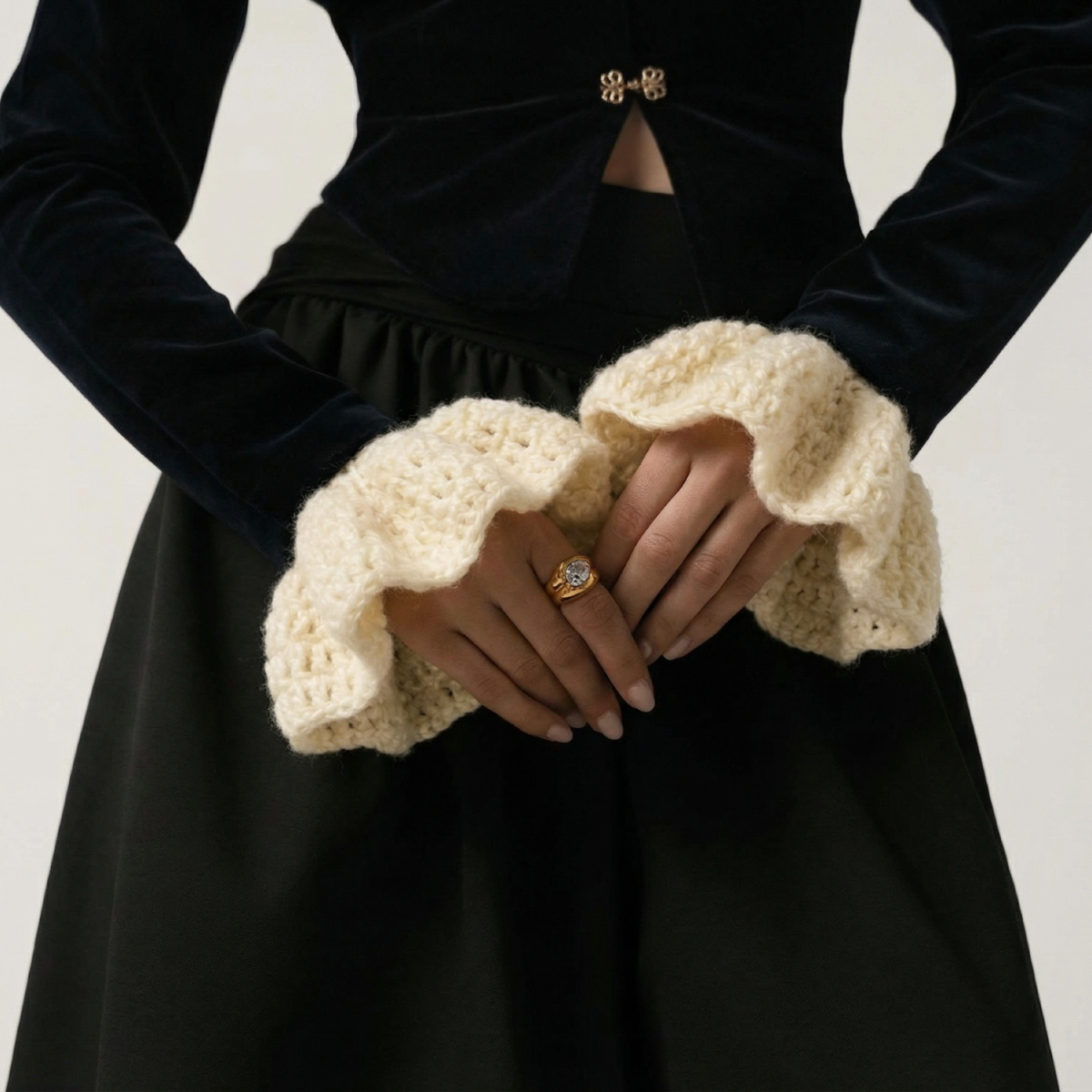 Modelka z dzierganymi rękawkami na nadgarstkach.