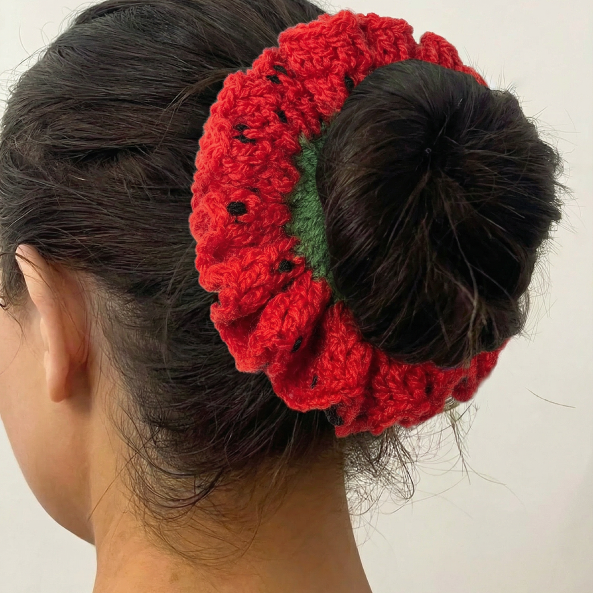Ręcznie robiona gumka do włosów na szydełku wykonana z materiałów z upcyklingu, pokazana na włosach modelki.