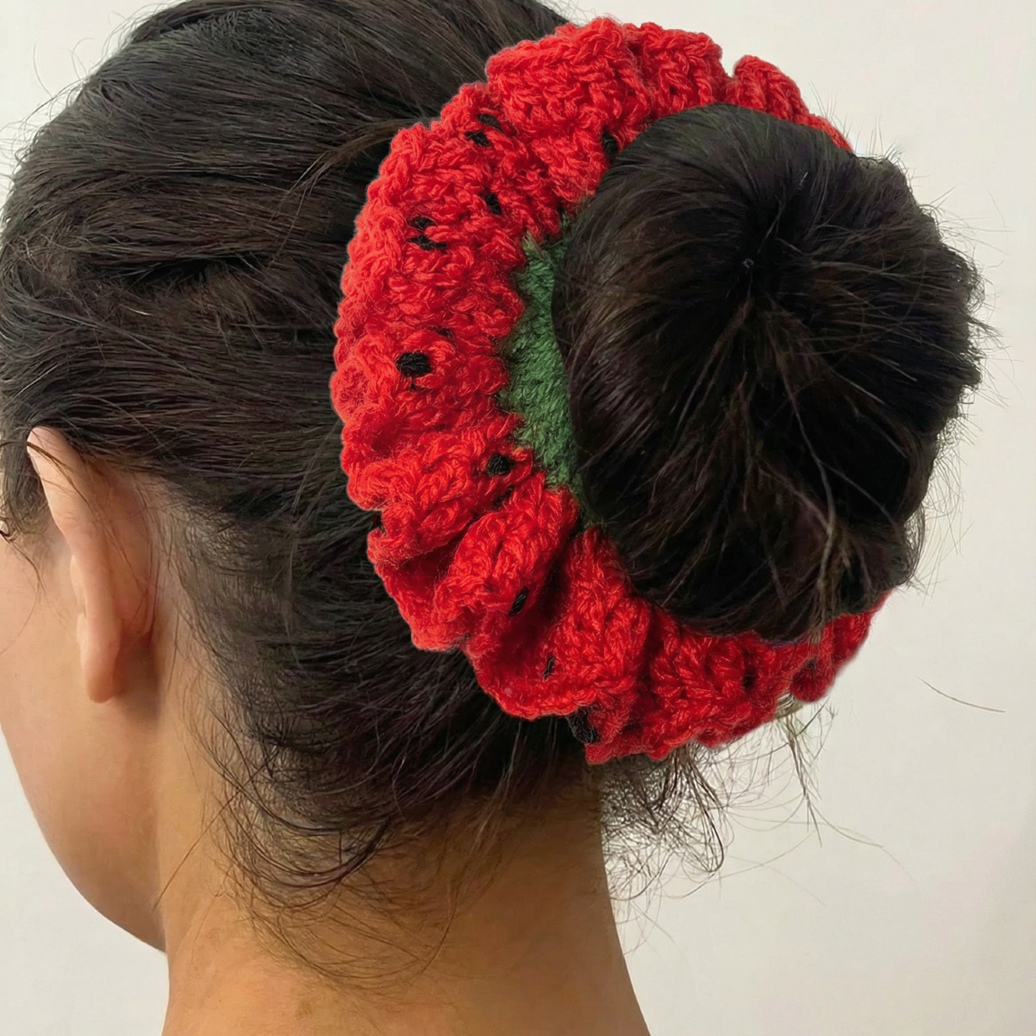 Ręcznie robiona gumka do włosów na szydełku wykonana z materiałów z upcyklingu, pokazana na włosach modelki.