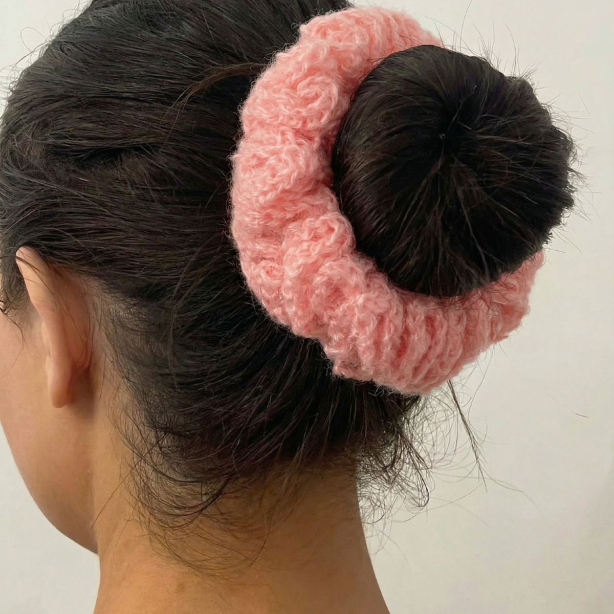 Ręcznie robiona gumka do włosów na szydełku wykonana z materiałów z upcyklingu, pokazana na włosach modelki.