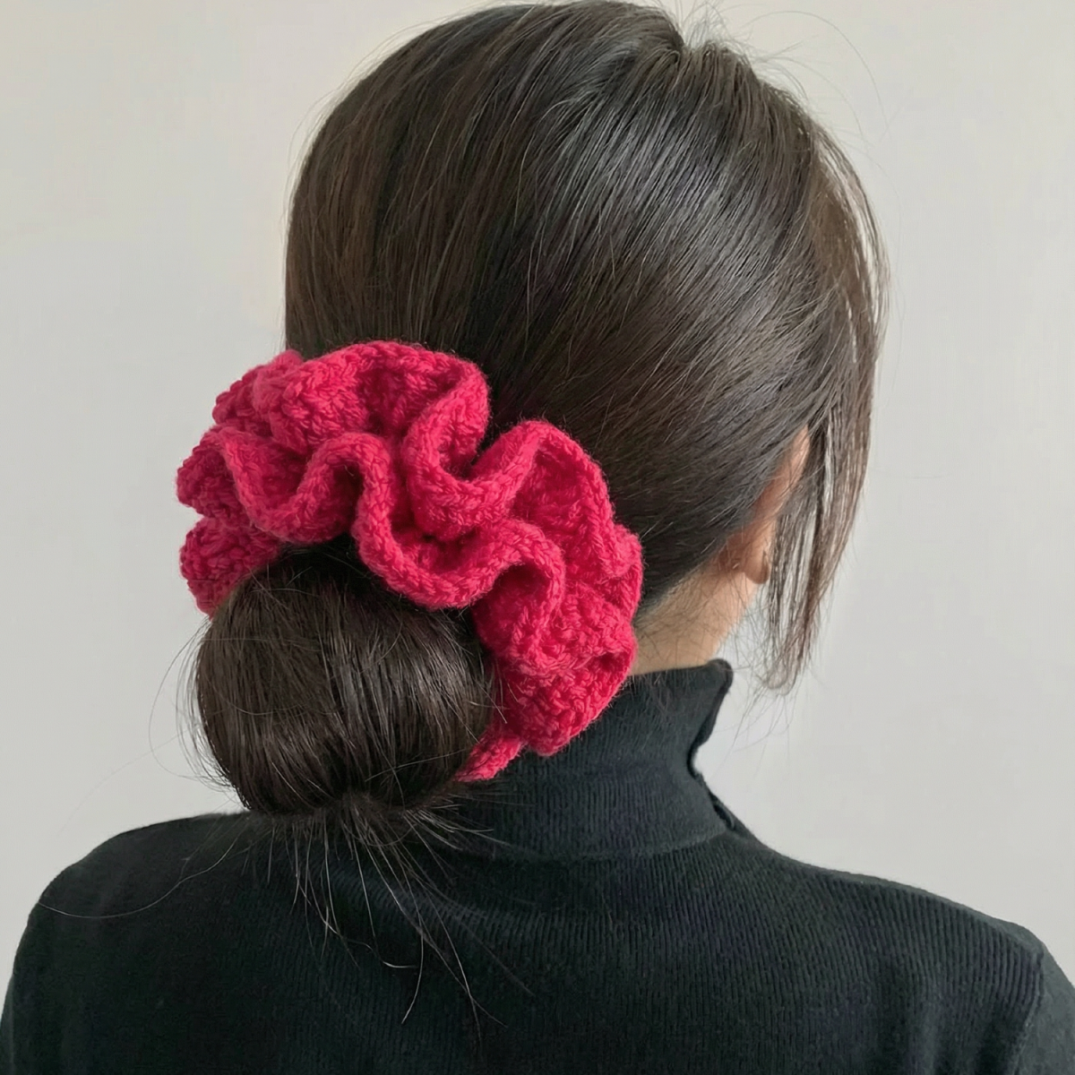 Ręcznie robiona gumka do włosów na szydełku wykonana z materiałów z upcyklingu, pokazana na włosach modelki.