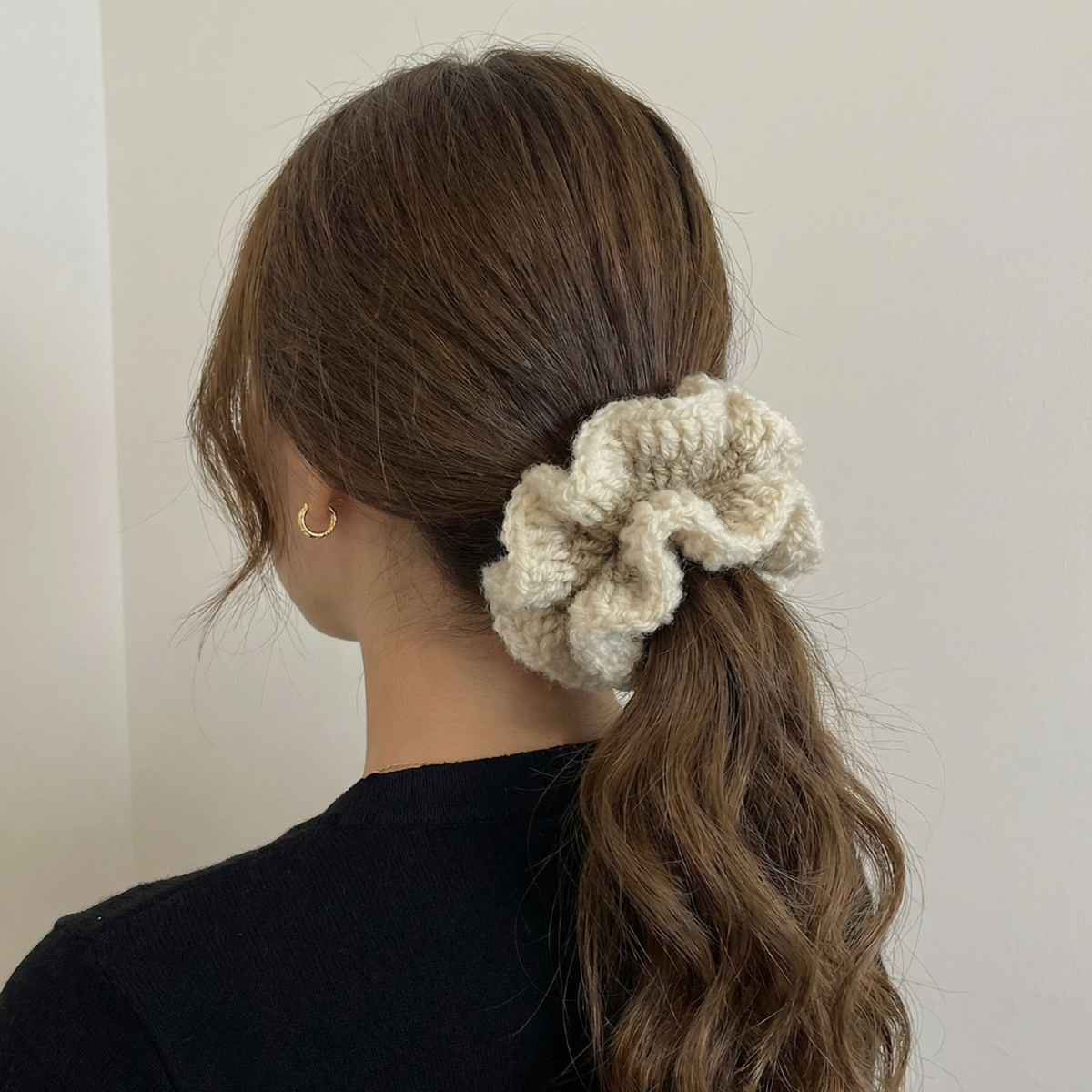 Ręcznie robiona gumka do włosów na szydełku wykonana z materiałów z upcyklingu, pokazana na włosach modelki.
