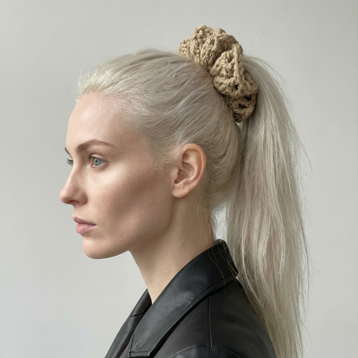 Ręcznie robiona gumka do włosów na szydełku wykonana z materiałów z upcyklingu, pokazana na włosach modelki.