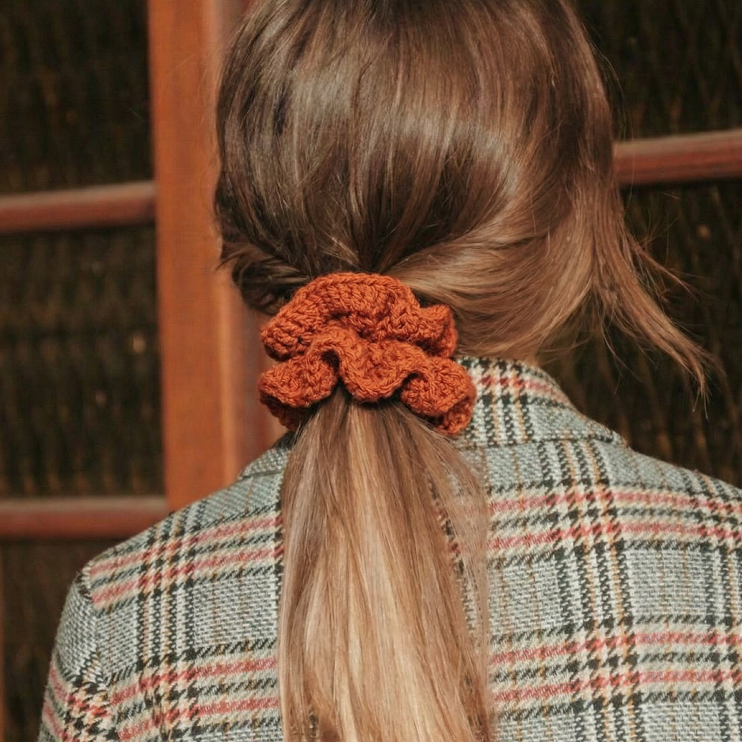 Ręcznie robiona gumka do włosów na szydełku wykonana z materiałów z upcyklingu, pokazana na włosach modelki.