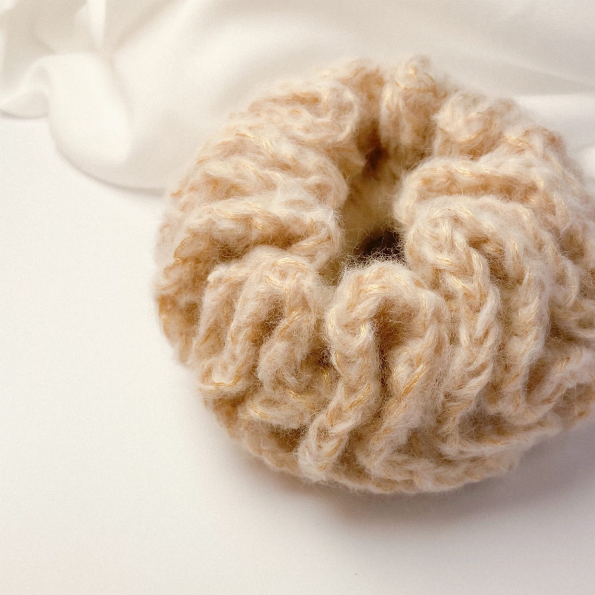 Ręcznie robiona, złota, puchata  gumka do włosów na szydełku wykonana z materiałów z upcyklingu.