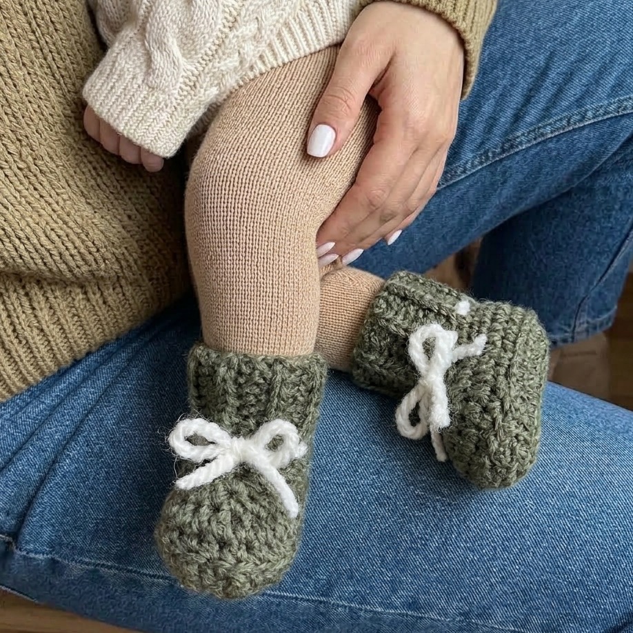 Ręcznie wykonane buciki niemowlęce niechodki z 100% baby alpaki na stópkach niemowlęcia. Miękkie buciki dla noworodka 0–3 miesiące, zakładane bezpośrednio na stópkę dzięki elastycznemu ściągaczowi.